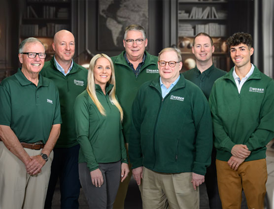 A diverse team of professionals in green jackets poses together, showcasing unity and expertise on the Home page.