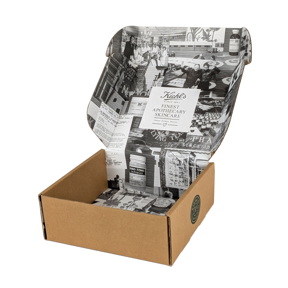 Open cardboard box featuring vintage-style black and white graphics, promoting Kiehl's skincare products.