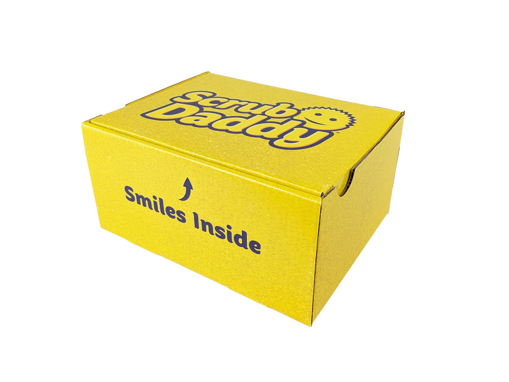 Bright yellow packaging box with "Scrub Daddy" branding and "Smiles Inside" text, designed for e-commerce shipping.