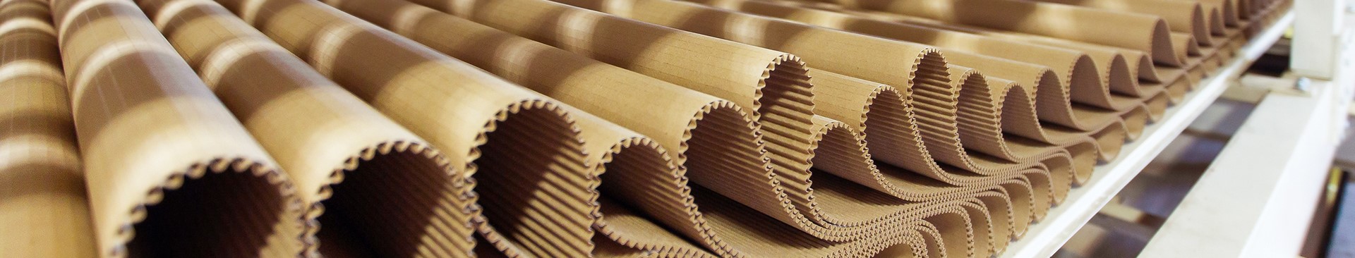 Corrugated cardboard sheets stacked in a factory, highlighting manufacturing processes relevant to career opportunities.